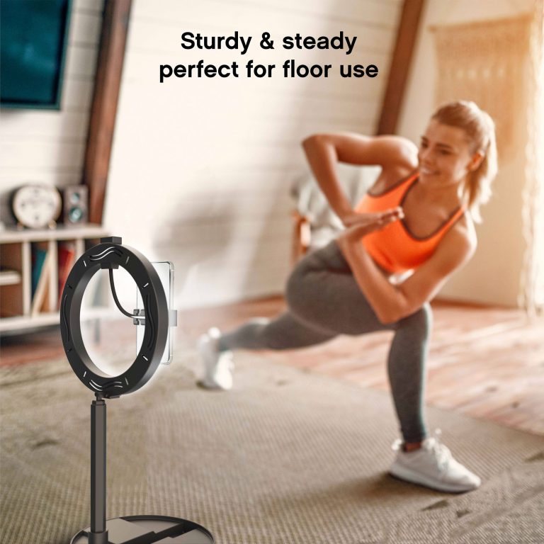 Woman doing yoga in her living room while watching an instructional video on her phone, as the Halo Travel Pro steadily holds it in the holder.