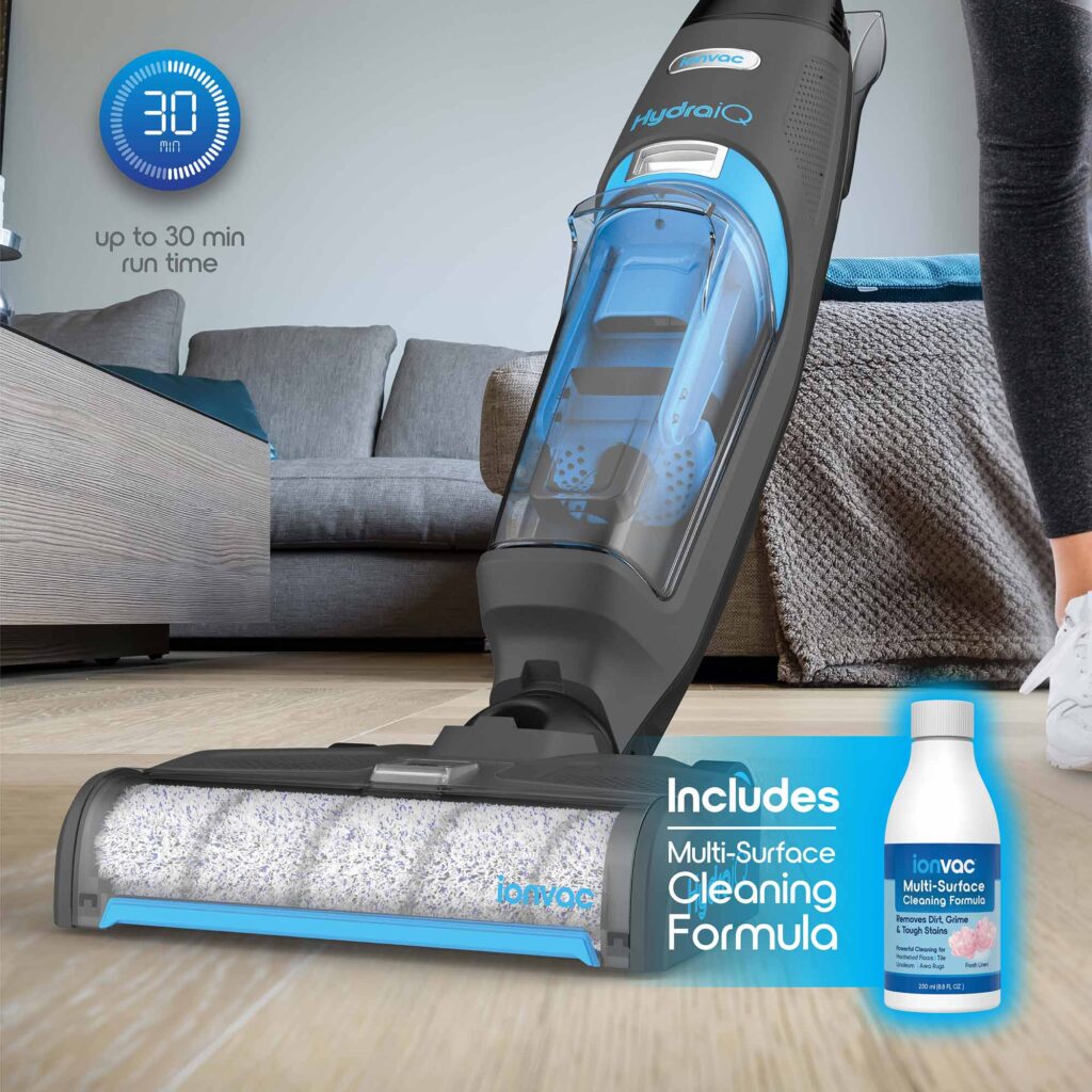 A woman using the HydraiQ to completely clean her living room floor, thanks to the included multi-surface cleaning formula.