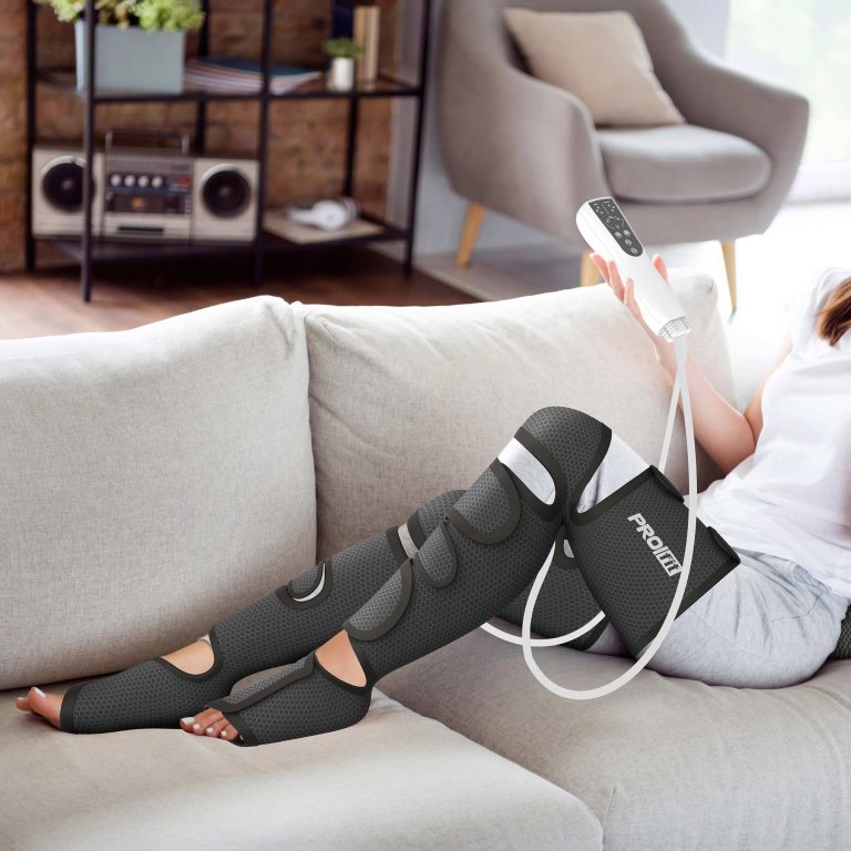 A woman relaxing on the couch in her living room after a long day, while wearing the Leg Compression Massager.